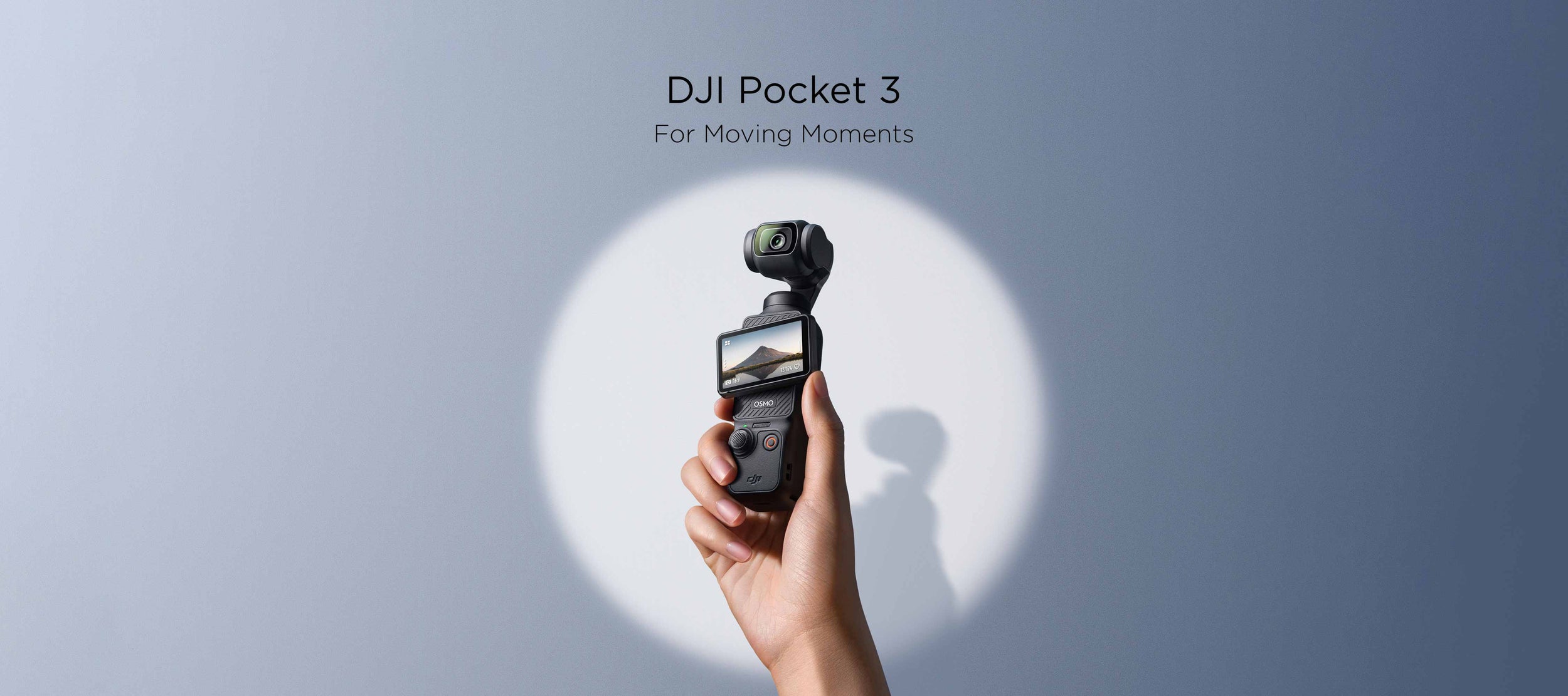 A hand holding up a DJI Pocket 3 against a blue background.