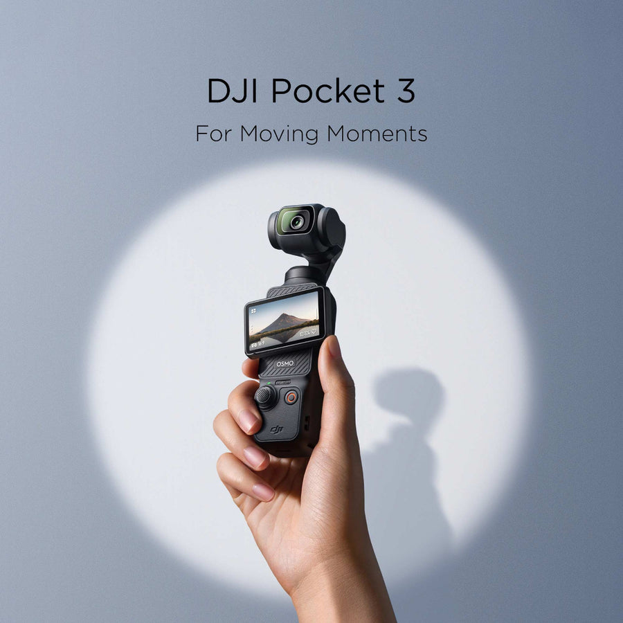 A hand holding the DJI Pocket 3 against a blue background with spotlight lighting.