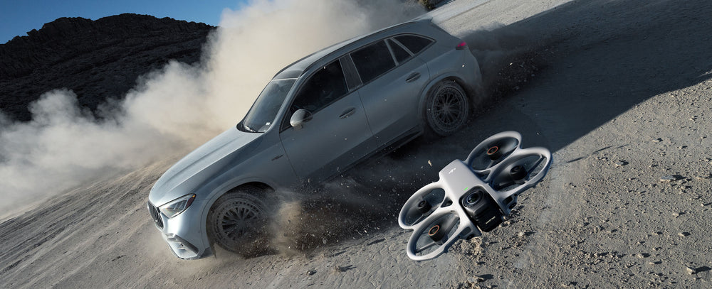A DJI Avata 360 flies over a moving vehicle in this still shot.