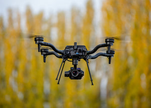 Freefly Astro in flight with blurred trees in the background